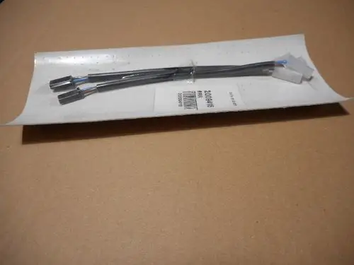 Spulenverbindung von Remeha, bestehend aus zwei kabelgebundenen Anschlüssen, die auf einer Verpackung liegen. Die Anschlüsse sind in einer transparenten Folie verpackt.